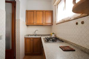 een keuken met houten kasten en een fornuis met oven bij B&B Colli's Dolomites in Belluno