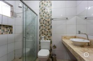 a bathroom with a toilet and a sink and a shower at Pousada Pé de Cedro in Bonito