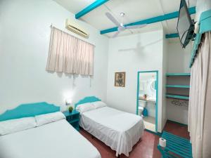 a bedroom with two beds and a mirror at Hotel Petenchel in Flores