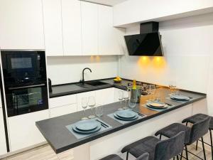 a kitchen with a table with plates and wine glasses at City Vibe Apartments in Someşeni