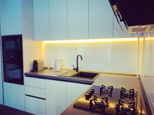 a kitchen with a stove top and a sink at City Vibe Apartments in Someşeni