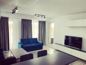a living room with a blue couch and a tv at City Vibe Apartments in Someşeni