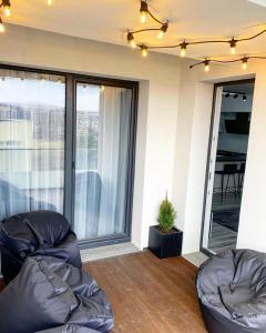 a living room with two chairs and a balcony at City Vibe Apartments in Someşeni