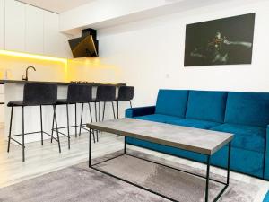 a living room with a blue couch and a table at City Vibe Apartments in Someşeni