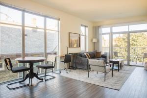 a living room with a couch and a table and chairs at East Side Luxury 1BR Apt - Near Brady and Fiserv with Balcony in Milwaukee