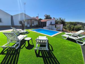 a yard with lawn chairs and a swimming pool at Fatima Villas in Ourém