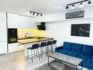 a kitchen with a blue couch and a kitchen island at City Vibe Apartments in Someşeni