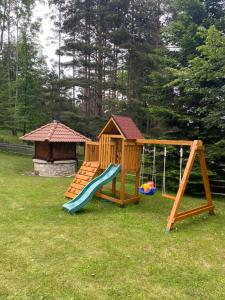 a wooden playground with a slide and a gazebo at Vikendica Tarsko srce S in Mitrovac