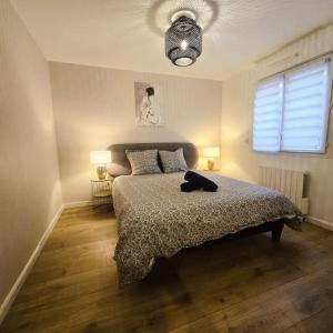 a bedroom with a bed and two lamps and a window at L'Apaisant in Thonon-les-Bains