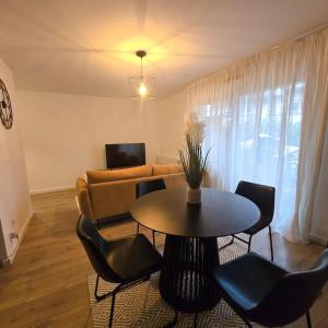 a living room with a table and chairs and a couch at L'Apaisant in Thonon-les-Bains +6 photos