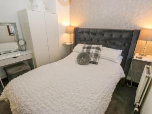 a bedroom with a bed with a pillow on it at Moor Cottage in Oldham