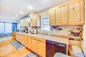 a kitchen with wooden cabinets and a sink at Cozy Colorado Springs Home Near Garden of the Gods in Colorado Springs