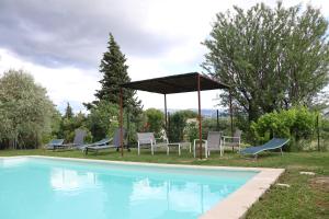 a group of chairs and a gazebo next to a pool at IA ORANA in Gargas