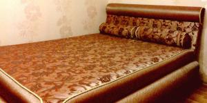 a bed in a room with a brown bed frame at Petropavlovskaya in Sumy