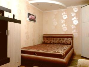 a couch in a room with flowers on the wall at Petropavlovskaya in Sumy