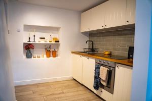 a kitchen with white cabinets and a counter top at North Wales Cottage Views, Walks, Dogs Welcome in Cilcain