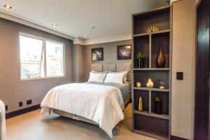 巴鲁埃里Flat com lazer, Wi-Fi e otima localizacao的带床和书架的卧室