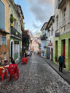 a cobblestone street with red chairs and tables on a cobblestone street at Katai in Salvador