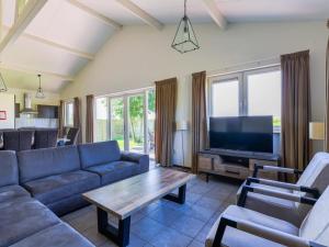a living room with a couch and a tv at Wilgenroos Vakantiepark De Groote Vliet in Wervershoof
