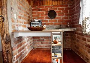 MalchinguíにあるCabaña en el Campo Malchinguí WIFI 24 horasのカウンターと棚のあるレンガ壁のキッチン +24枚の写真