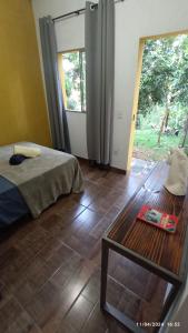 ein Schlafzimmer mit einem Bett, einem Tisch und einem Fenster in der Unterkunft Escalarte - Gruta da Lapinha in Lagoa Santa