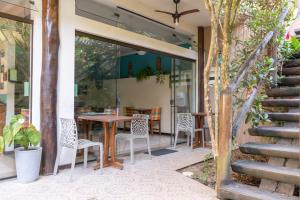 a patio with a table and chairs and a table at Pousada Aquarela do Mar in Abraão