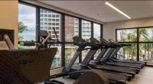 a gym with several treadmills in a room with windows at Salinas Premium 2 quartos C10 in Salinópolis