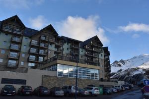 a building with cars parked in a parking lot at Résidence Les Adrets de Peyragudes in Germ