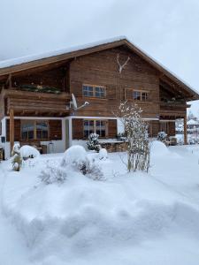 Una casa con nieve en el suelo delante de ella. en Chalet Tirolia, en Kirchdorf in Tirol