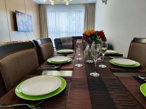 a table with plates and glasses and a vase of flowers at Lola's Haven - 75" Screen, Heated Pool, Gym, Views in Nairobi