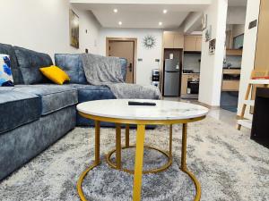 a living room with a blue couch and a table at Lola's Haven - 75" Screen, Heated Pool, Gym, Views in Nairobi +41 photos