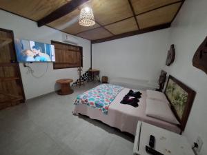 a bedroom with a bed and a flat screen tv at Espaço Sairé - 8 minutos da Praia in Alter do Chao