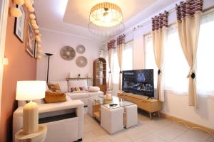 a living room with a couch and a tv at Plain-Pied - 5 couchages - Billard - BabyFoot - Terrasse - Jardin - Véranda - 4 chambres & canapé convertible - Netflix - Amazon Prime - WIFI - Stationnement gratuit devant - Verdun Centre - Géré par Presta-Zen'Services in Verdun
