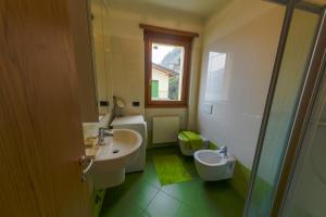 een badkamer met een wastafel, een toilet en een spiegel bij Residence degli Oleandri 4B in Argegno