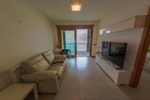 een woonkamer met een bank en een flatscreen-tv bij Residence degli Oleandri 4B in Argegno +21 foto's