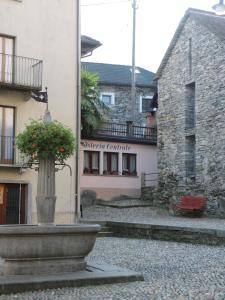 a vase with flowers in it in front of a building at Guesthouse "Castello del Nucleo" in Intragna