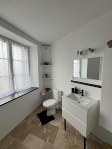 ein weißes Badezimmer mit Toilette und Waschbecken in der Unterkunft Charmante maison de bourg cosy accès wifi in Sepmes