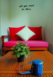 ein Wohnzimmer mit einem roten Sofa und einer Topfpflanze in der Unterkunft Loft con balcón en Roma Norte in Mexiko-Stadt