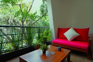 ein Wohnzimmer mit einem roten Sofa und einem Tisch in der Unterkunft Loft con balcón en Roma Norte in Mexiko-Stadt