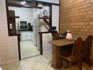 a kitchen with a table and chairs and a kitchen with a counter at Casa Solar Sansoan in Arraial do Cabo