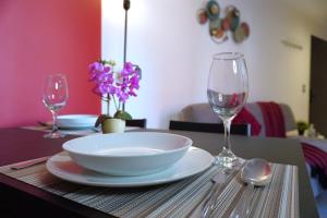 ein Tisch mit einer Schüssel und einem Teller und zwei Weingläsern in der Unterkunft Loft con balcón en Roma Norte in Mexiko-Stadt + 12 Fotos