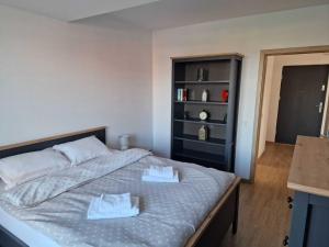 a bedroom with a bed with two white towels on it at City Vibe Apartments in Someşeni