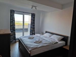 a bedroom with a bed with two towels on it at City Vibe Apartments in Someşeni