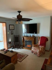 a living room with a fireplace and a chair at 3 guest rooms 2 shared baths in Milford
