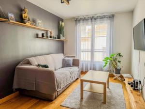 a living room with a couch and a table at Appartement moderne dans le centre de Chartres in Chartres