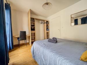 a bedroom with a bed and a desk and a chair at Appartement moderne dans le centre de Chartres in Chartres