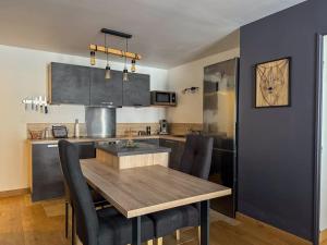 a kitchen with a wooden table and black chairs at Appartement moderne dans le centre de Chartres in Chartres +1 photo