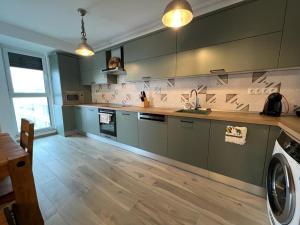 a large kitchen with a washer and dryer in it at City Vibe Apartments in Someşeni