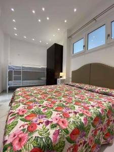 a bedroom with a large bed with a floral bedspread at Apartment in San Michele al Tagliamento 45651 in San Michele al Tagliamento