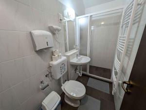 a white bathroom with a toilet and a sink at Holiday home in Siofok - Balaton 52077 in Siófok +16 photos